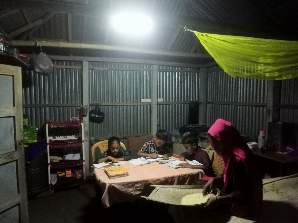 3.Kids of Rume Akter studying in the evening under brighter light of this SHS, and she is also doing some household activity,Vill-Dakshin Ulla, Union-Bharatkhali,Saghata.jpg